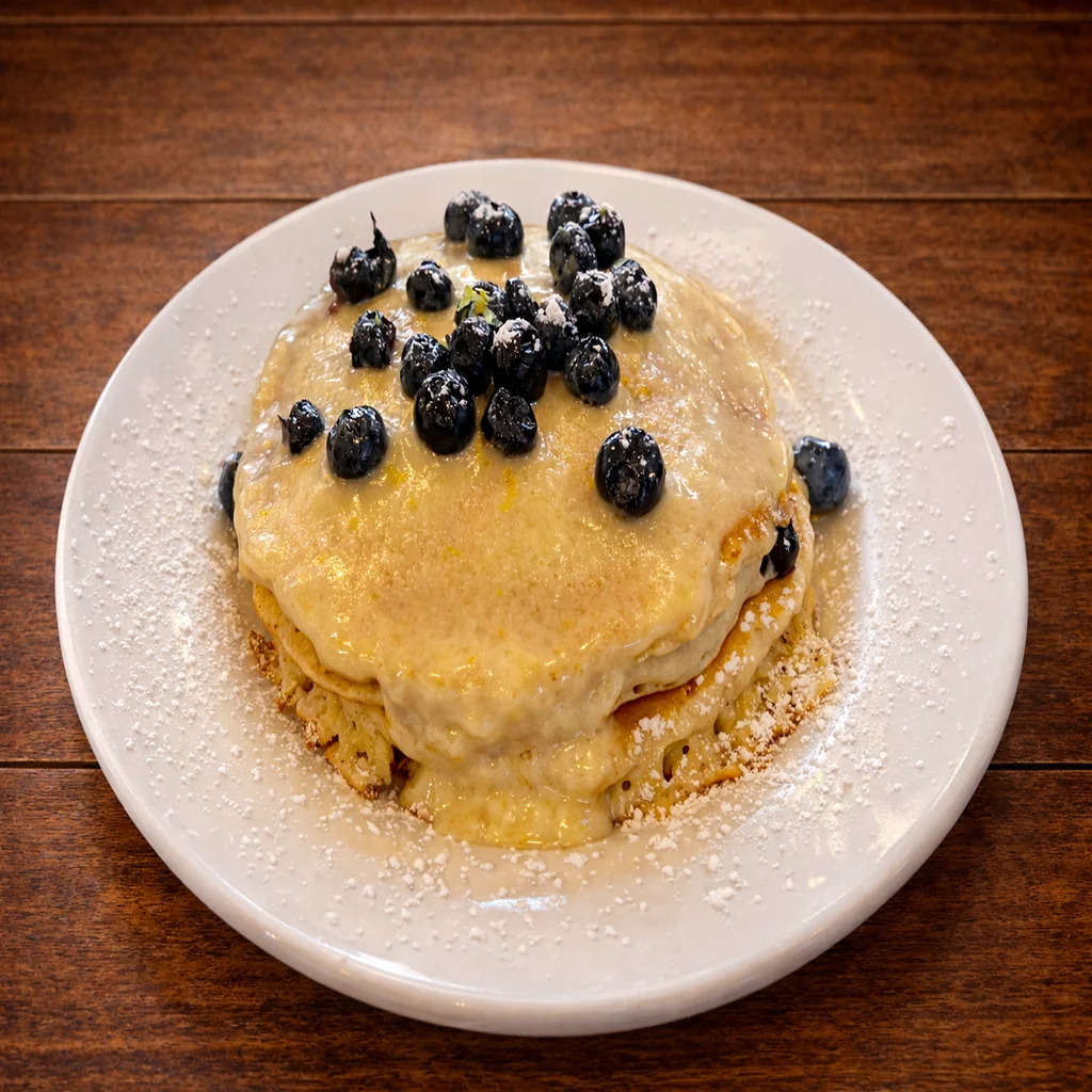 Blueberry pancakes topped with powdered sugar and syrup