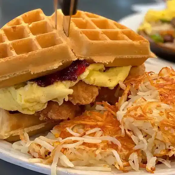 Chicken and waffles served with eggs and hash browns