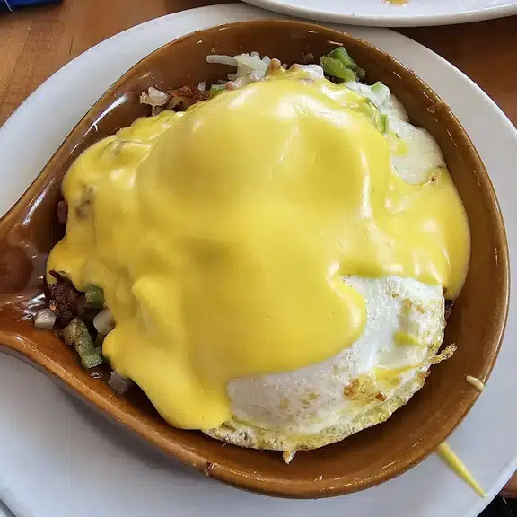 Eggs Benedict with hollandaise sauce on English muffin